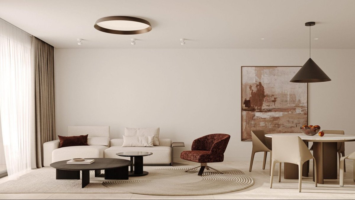 Modern living room with white sofa, brown accent chair, and dining area.