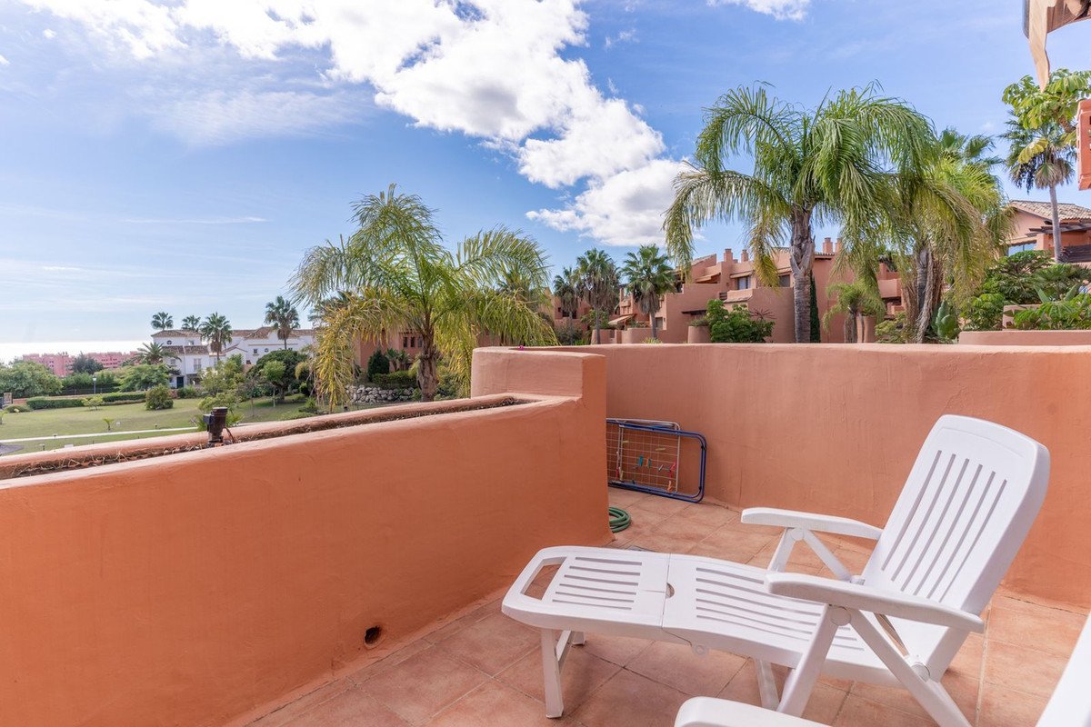 Sunny terrace with white lounge chairs and palm tree views