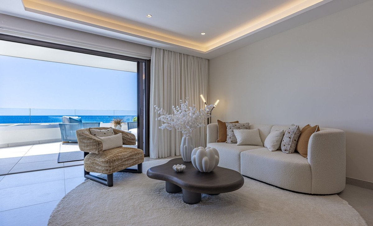 Modern living room with a comfortable sofa, unique armchair, and a stunning sea view from the open terrace.