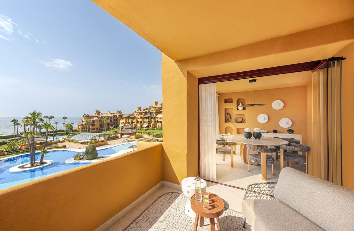 Terrace with pool and sea view, leading into a dining area with a table and chairs.