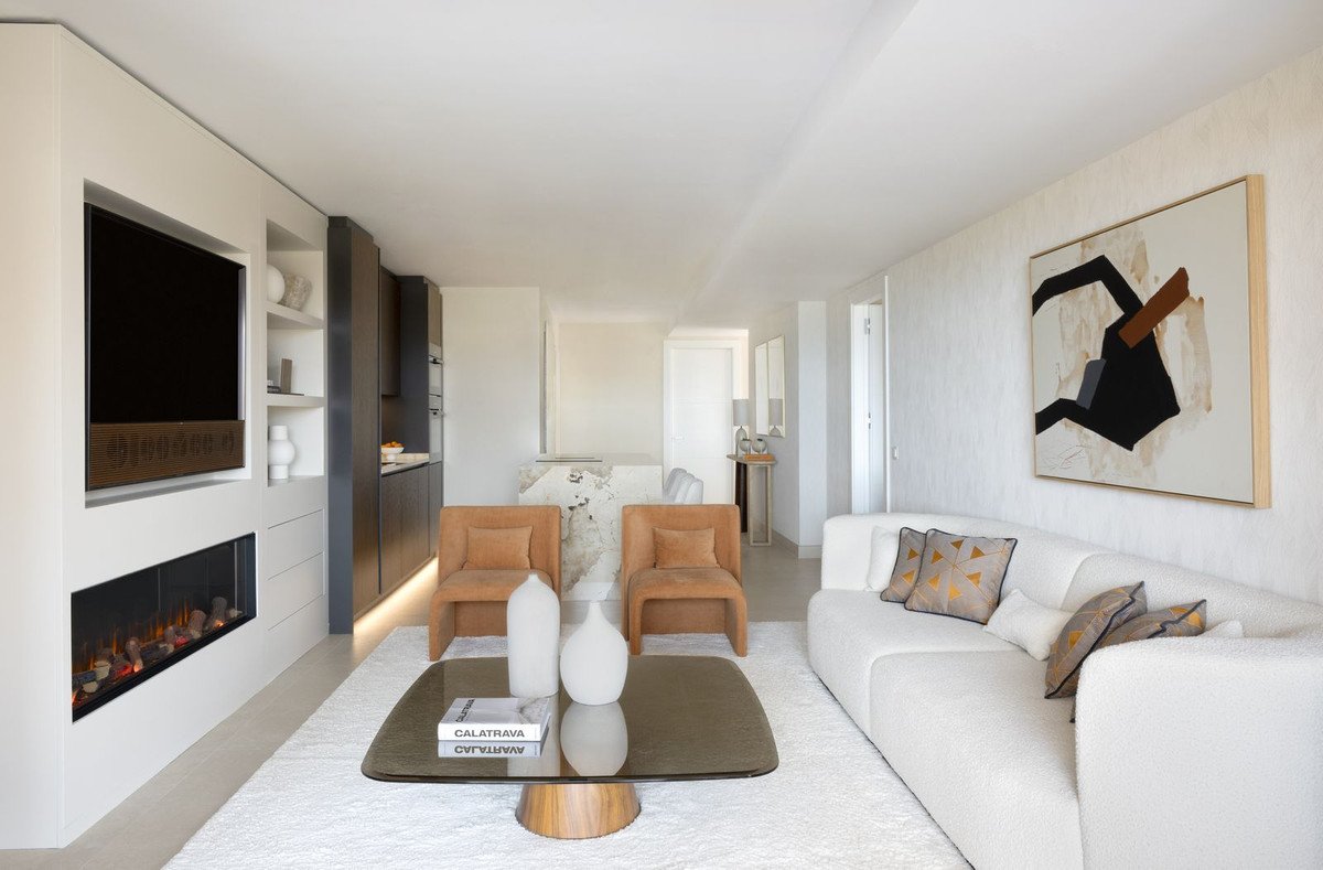 Modern living room with a built-in fireplace and TV, comfortable sofa, and accent chairs.