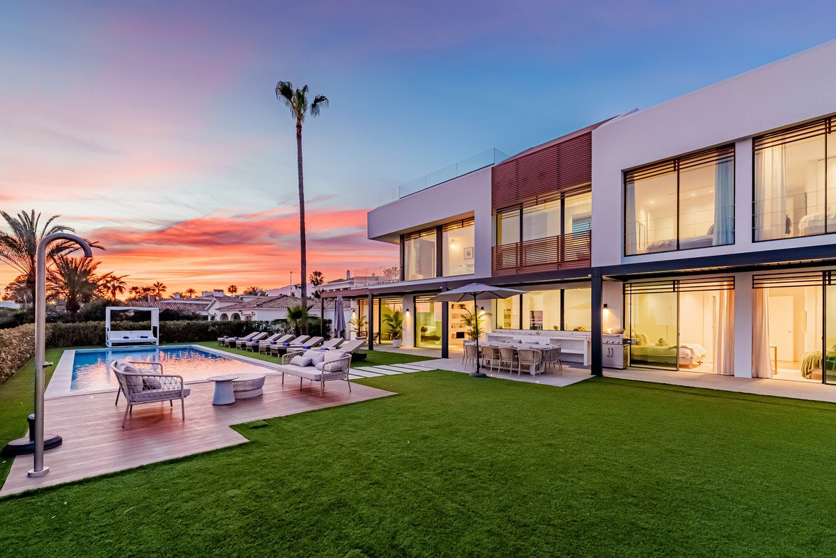 Modern villa with swimming pool and outdoor seating area at sunset