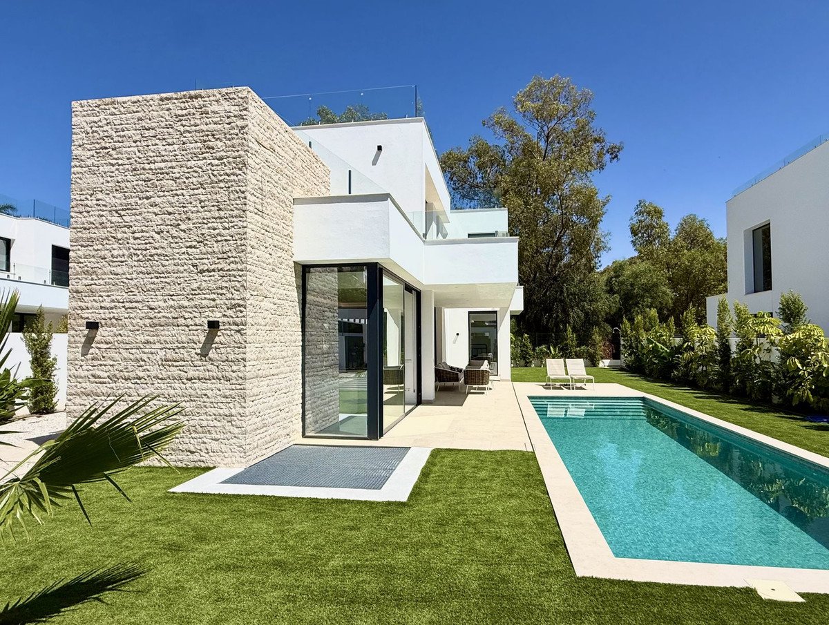 Modern villa with a swimming pool, glass doors, and outdoor seating area