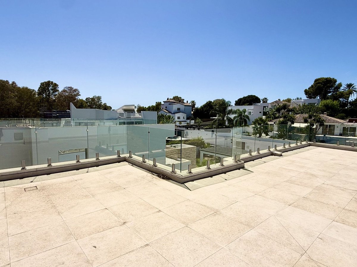 Rooftop terrace with glass railing and panoramic views of surrounding buildings