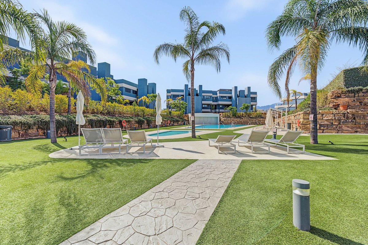 Apartment complex with swimming pool, lounge chairs, and manicured lawn.