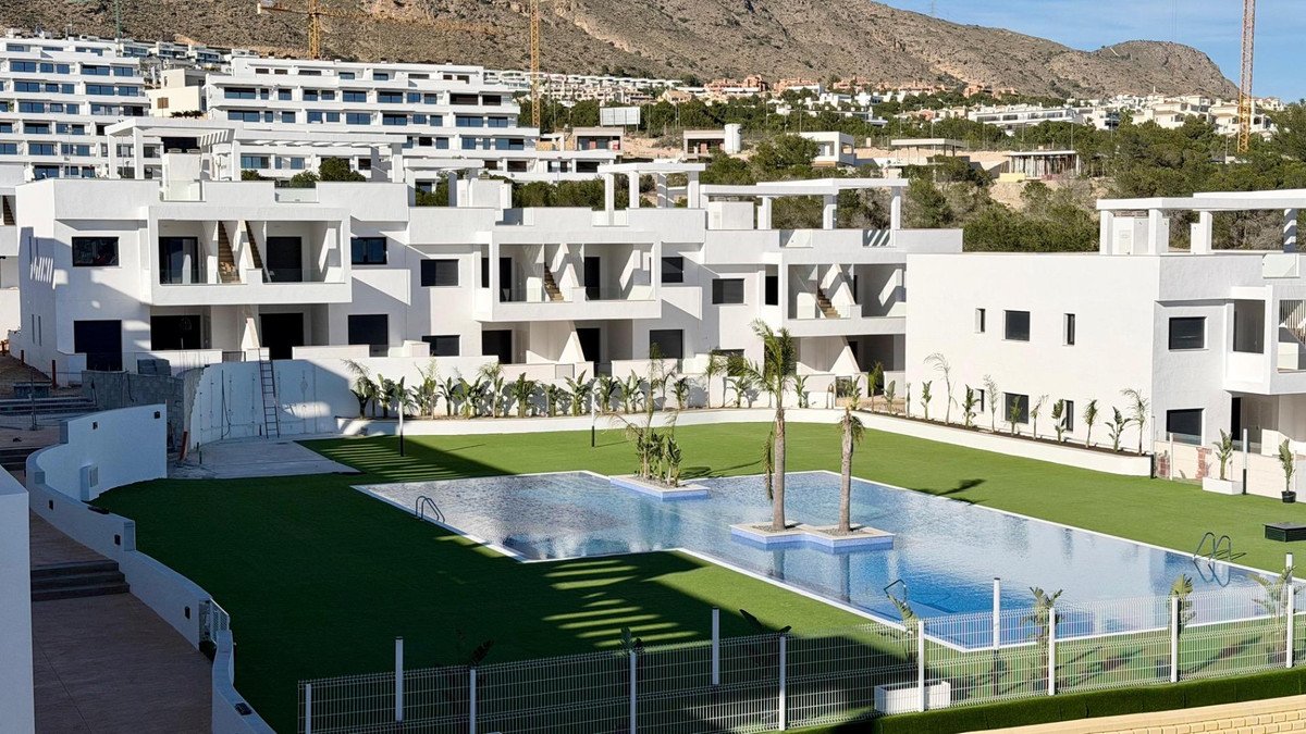 Modern white apartment complex with swimming pool and mountain view