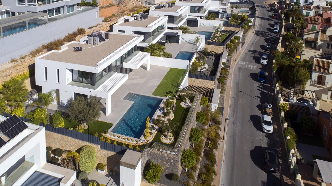 Luchtfoto van een moderne villa met zwembad en weelderige tuinen.