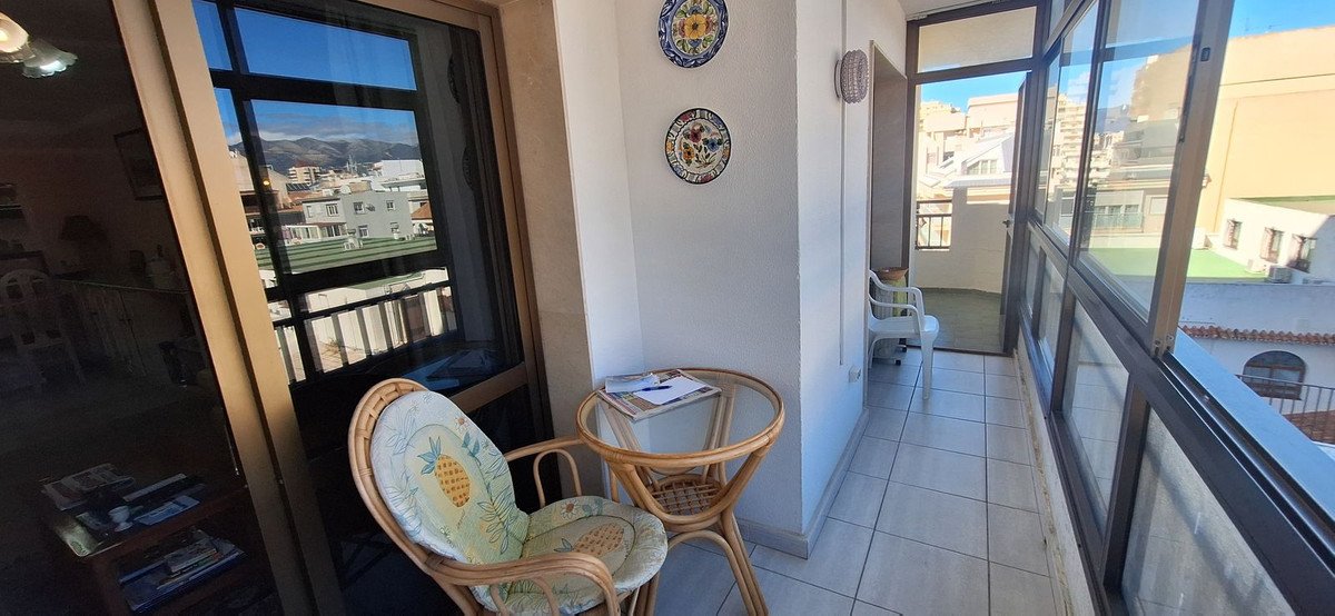 Balkon s pogledom na mesto, ratan stoli, majhno mizo, dekorativnimi krožniki.