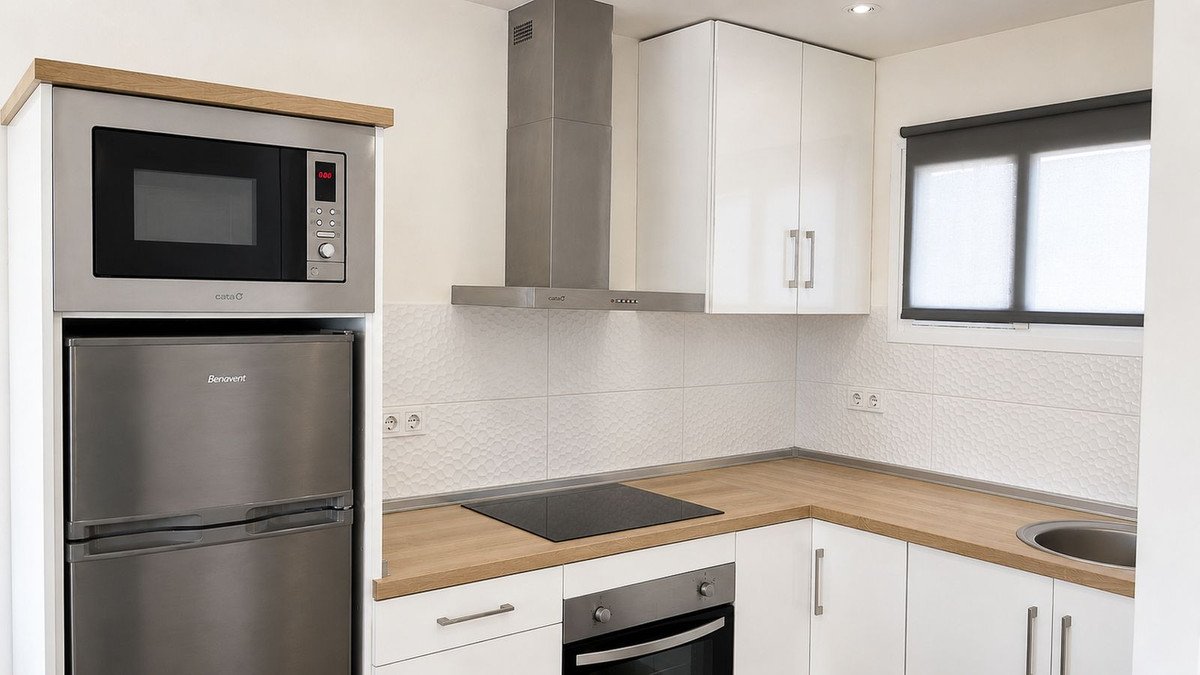 Modern kitchen with white cabinets, wooden countertops, a built-in microwave, refrigerator, oven, and range hood.