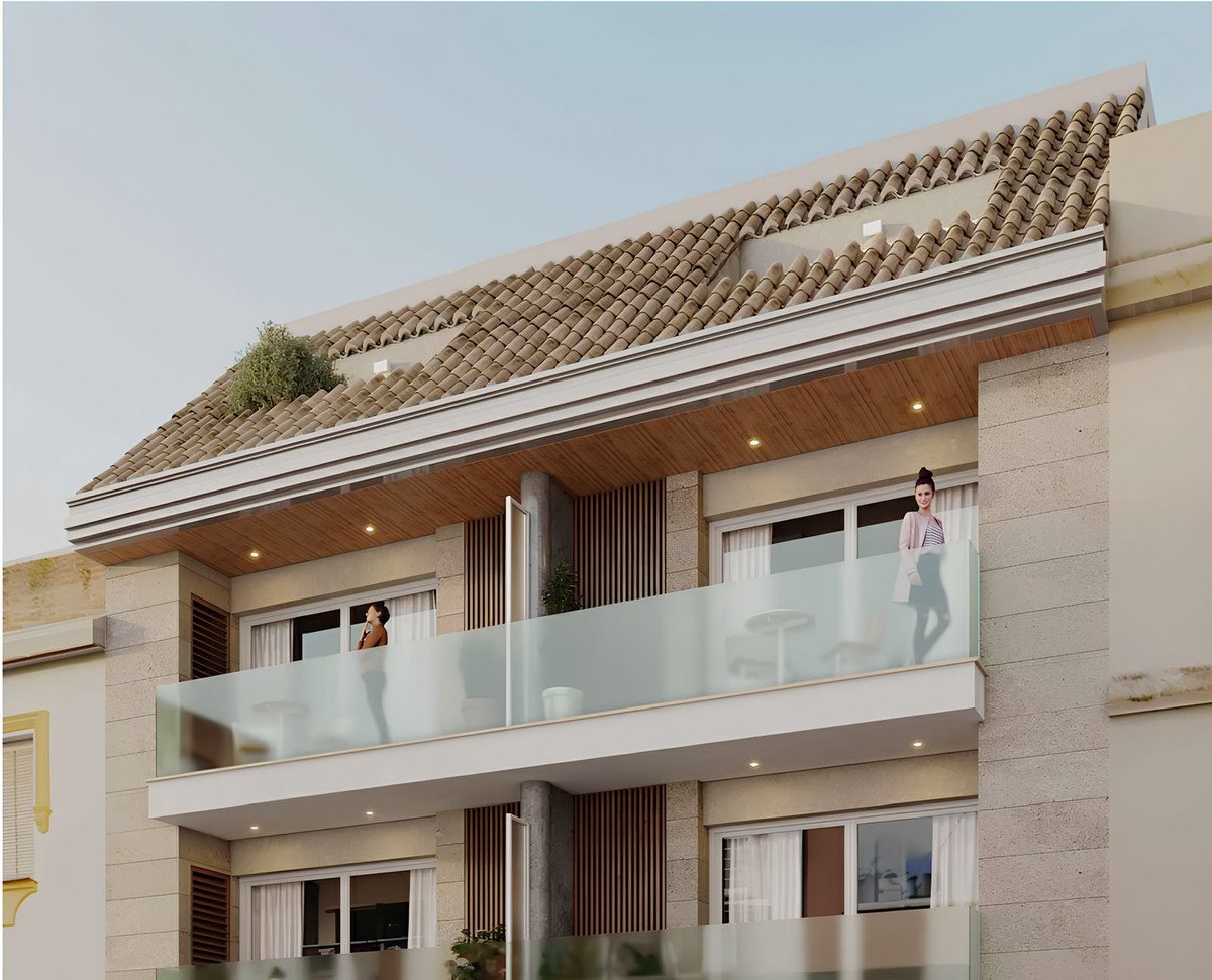 Modern apartments with glass balconies and an attractive tiled roof under a clear sky.