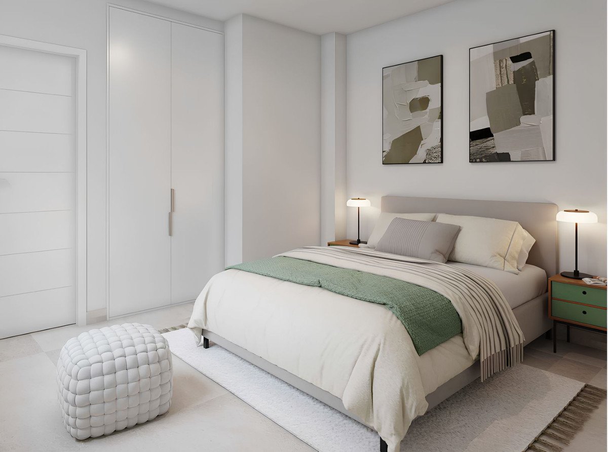 A modern bedroom with a king-size bed, neutral bedding, green throw, abstract art, and a built-in closet.