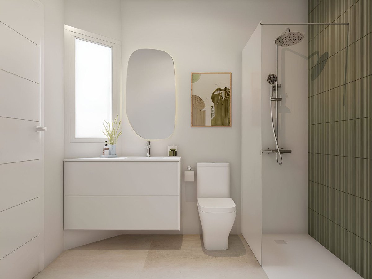 A modern bathroom with a white vanity, toilet, and a walk-in shower with tiled walls. Features a large mirror and artwork.