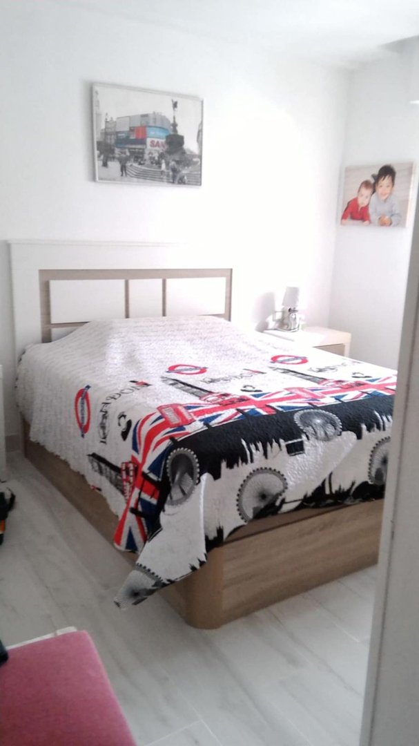 Bedroom featuring a queen-size bed with a Union Jack and London-themed duvet and artwork on the walls.