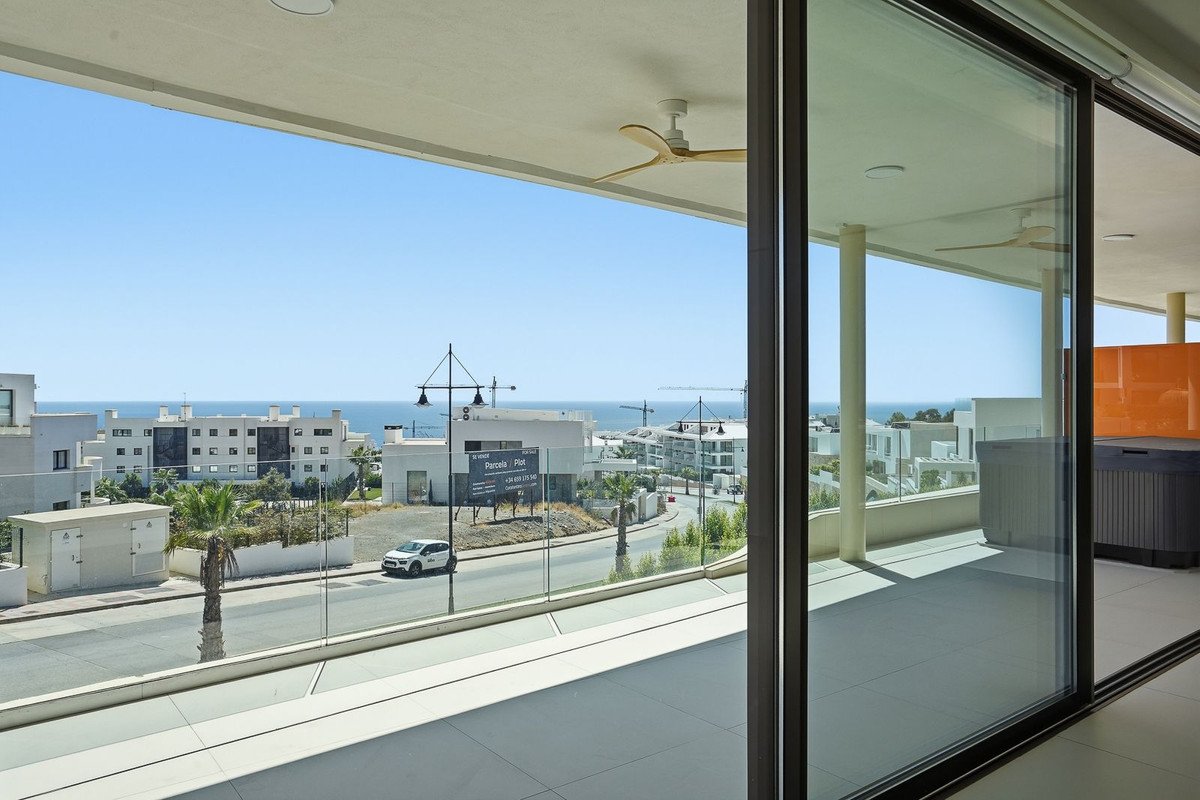 Modern apartment balcony with sea view, featuring a jacuzzi and contemporary architecture.
