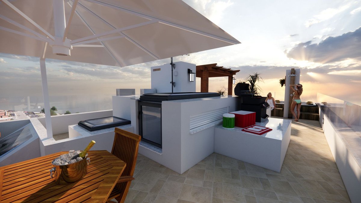 Rooftop terrace with outdoor kitchen, grill, seating area, and sea view at sunset.
