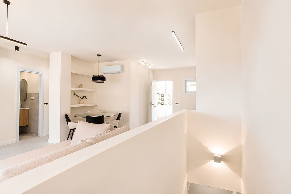 Modern open-plan living and dining area with white decor and natural light