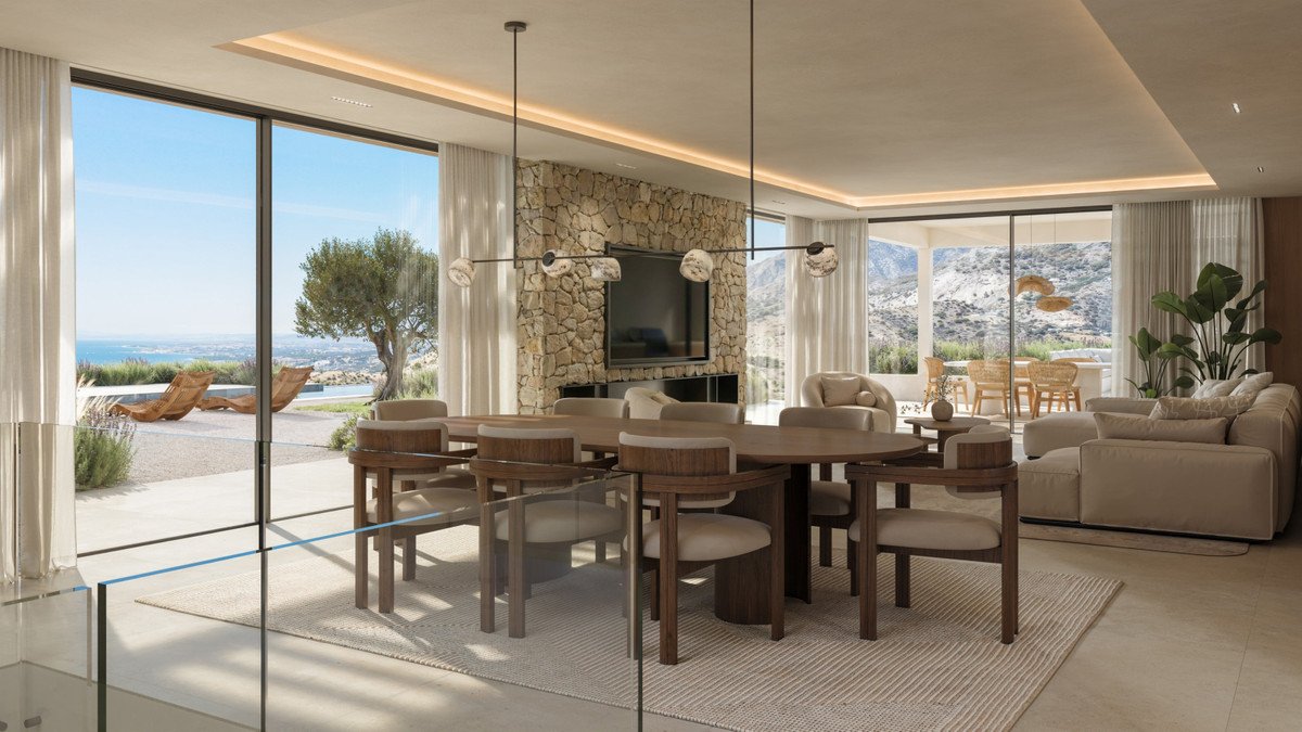 Modern living room with stone fireplace, large windows, and ocean view.