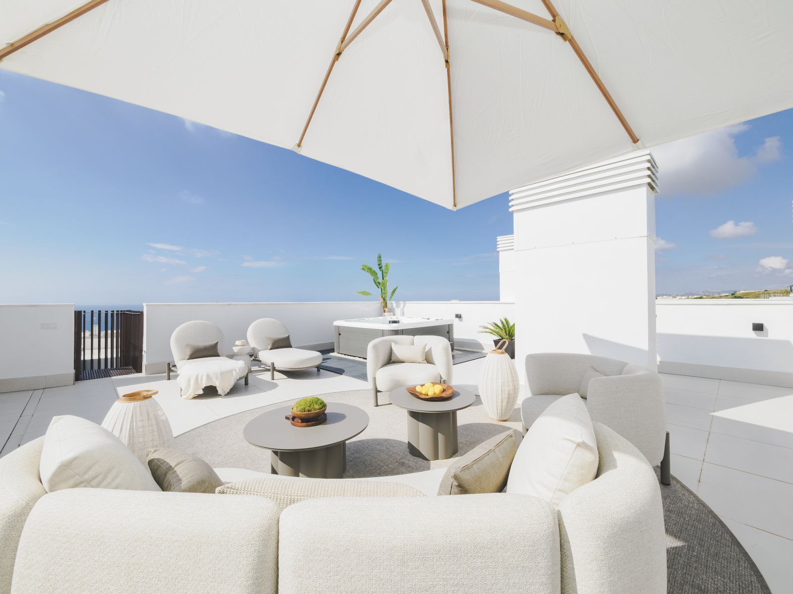 Luxe dakterras met uitzicht op de oceaan en witte loungebank.