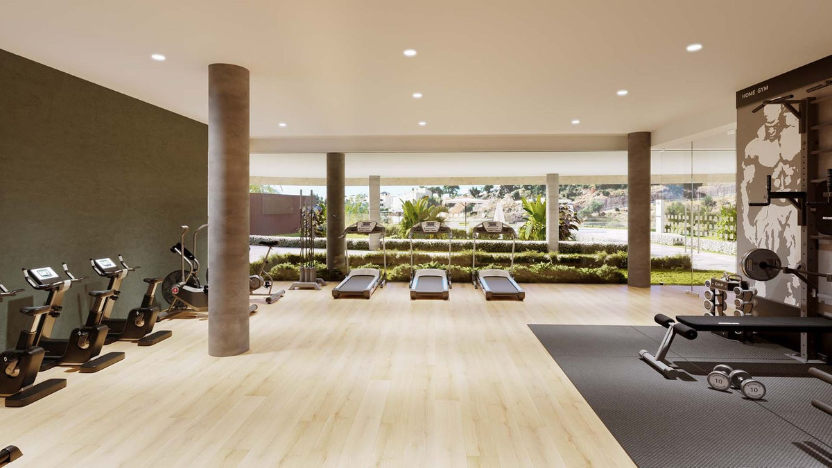 Moderne fitnessruimte in Korall Residences met diverse apparatuur en uitzicht naar buiten.
