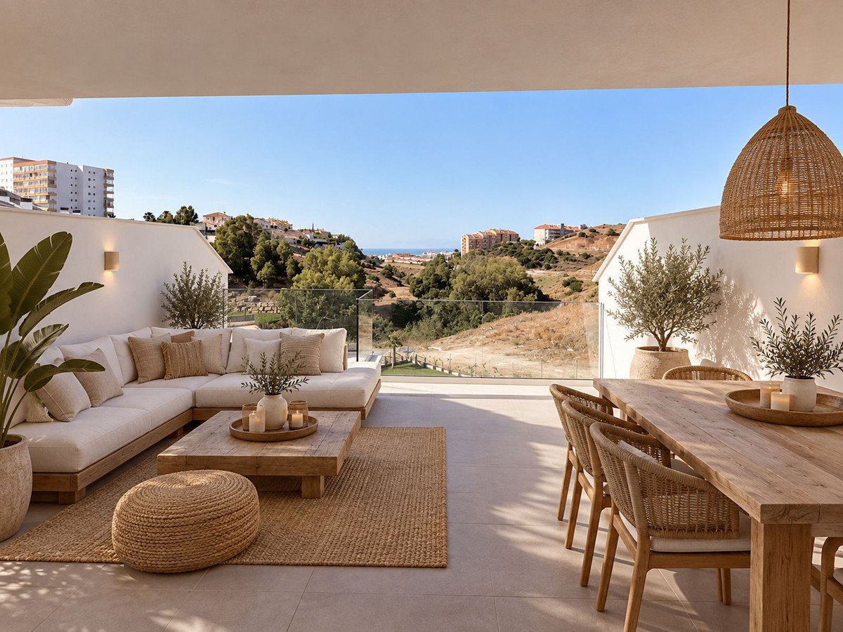 Spacious terrace with lounge seating and dining table, overlooking a hilly landscape with distant sea views.