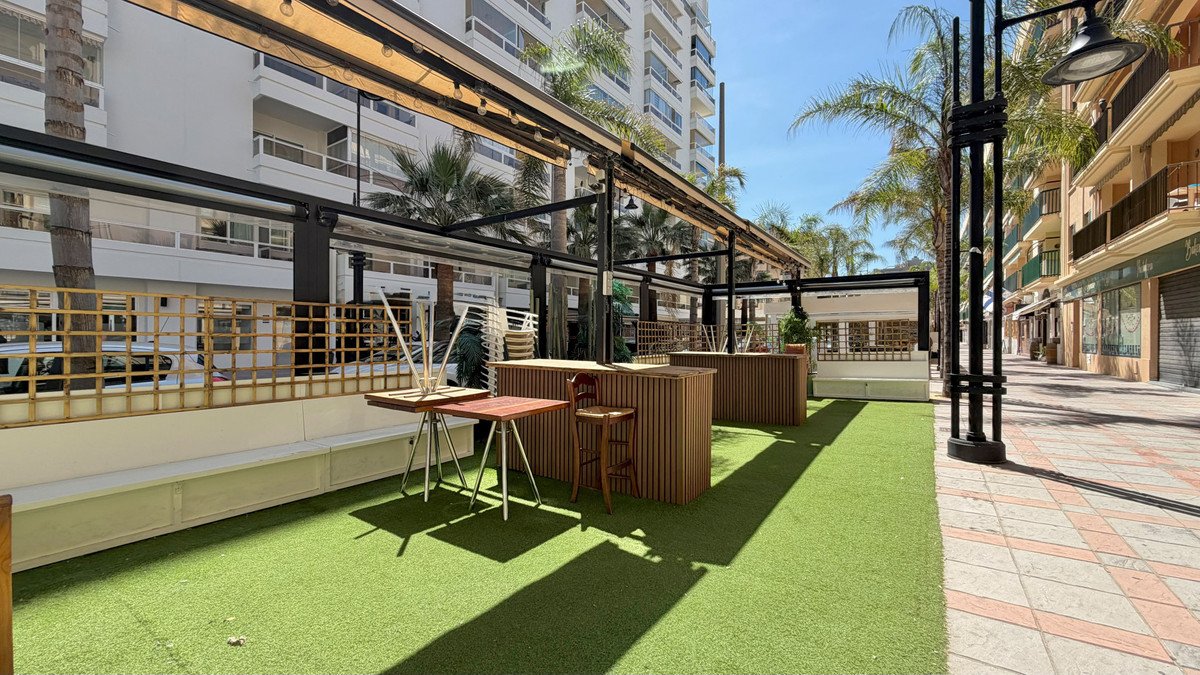Outdoor lounge area with green grass and seating under pergola