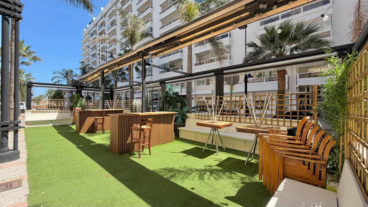 Modern outdoor lounge area with green grass and wooden furniture
