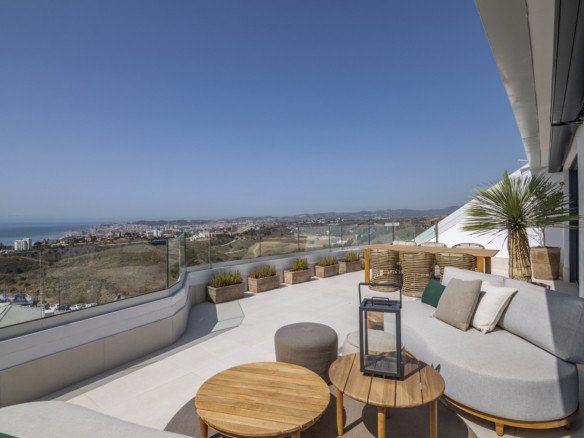 Modern terrace with comfortable seating and coffee tables offering panoramic sea and cityscape views.