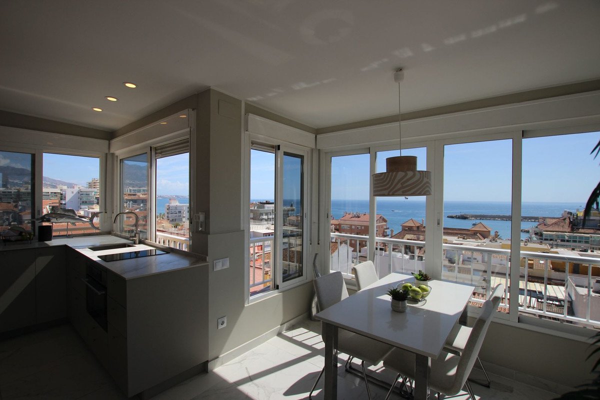 Modern kitchen and dining area with panoramic sea views through large windows.