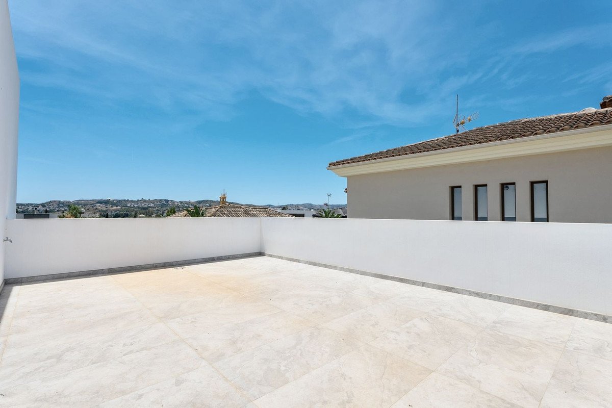White tiled rooftop terrace with panoramic city view under clear blue sky