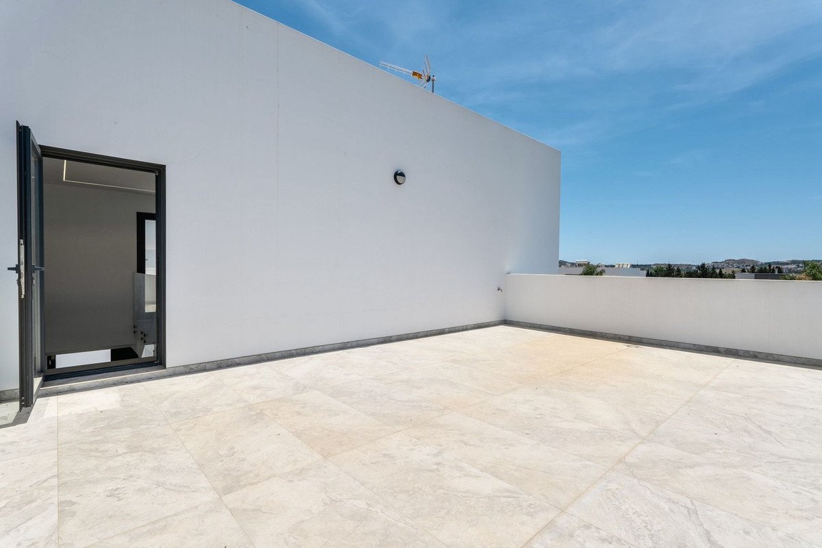 White modern rooftop terrace with open door and clear blue sky view
