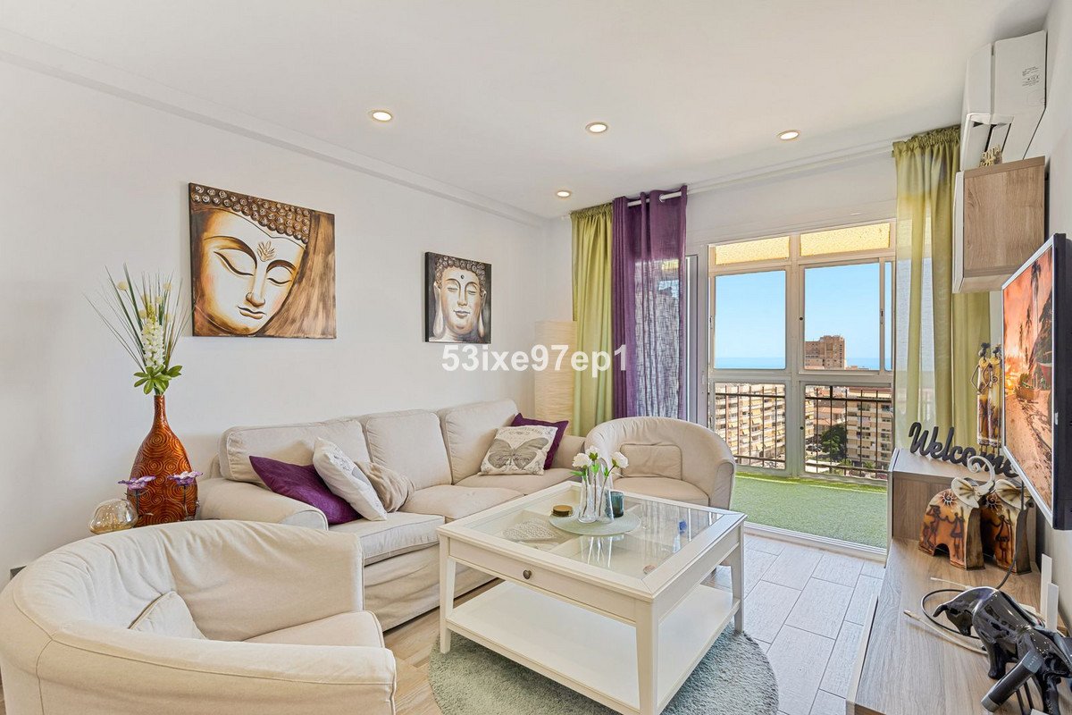 Bright living room with comfortable sofas, coffee table, and a balcony with sea and sea view.
