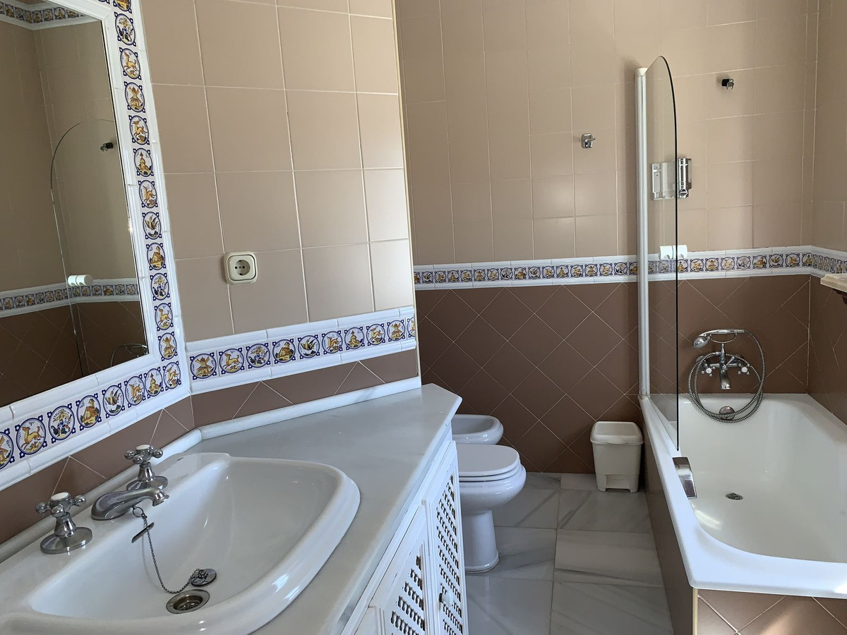 Badkamer met wastafel, toilet en badkuip.