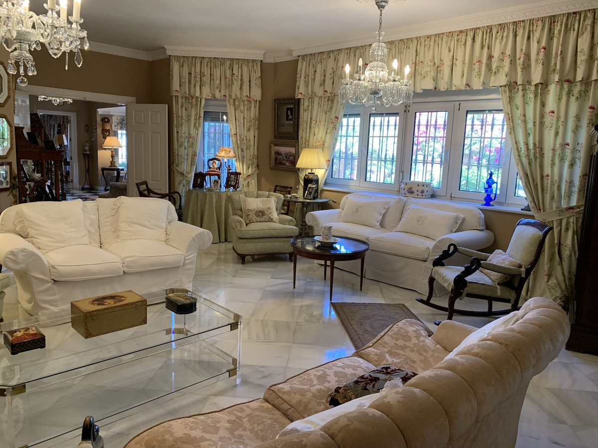 Luxe ingerichte woonkamer met klassieke meubels en marmeren vloer.