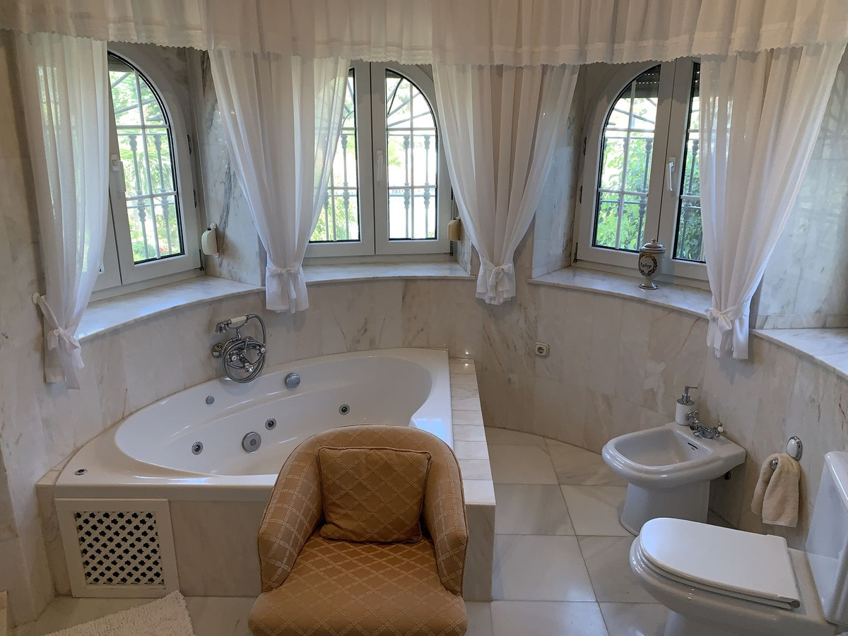 Luxe badkamer met marmeren afwerking, ligbad en toilet