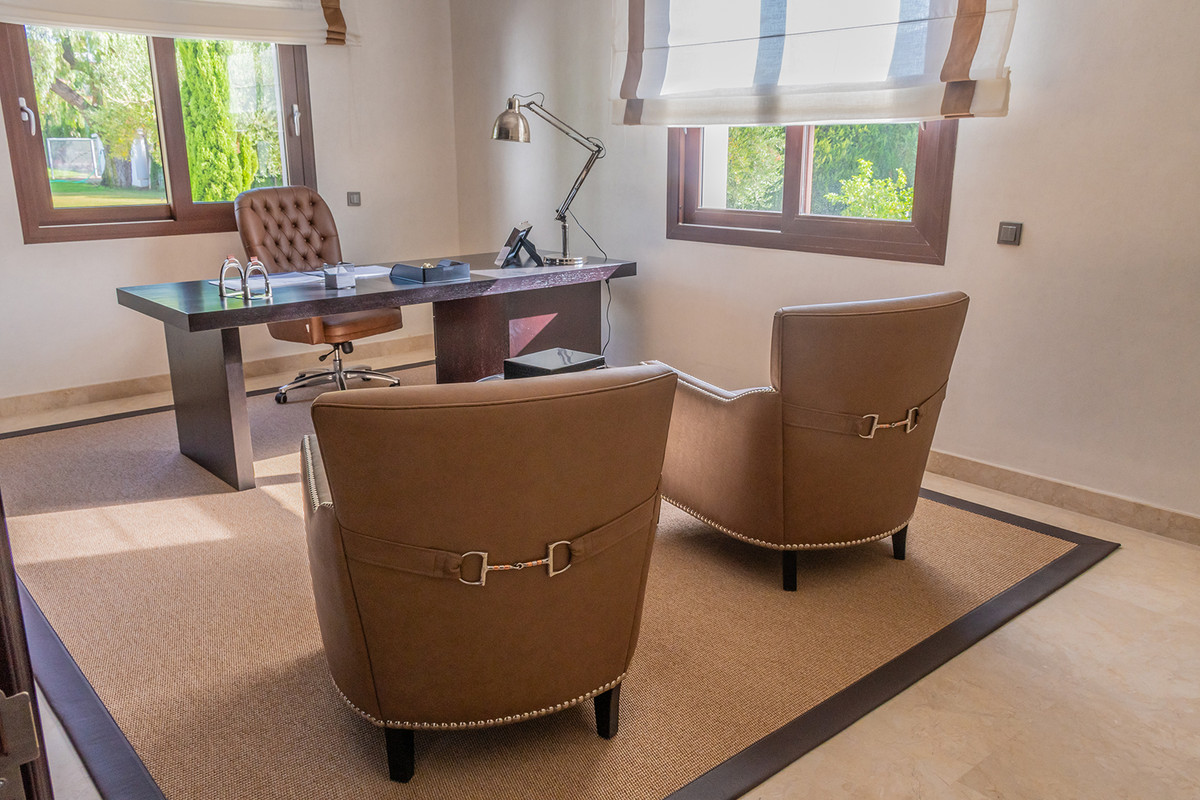 Elegant thuiskantoor met bureau en comfortabele stoelen.