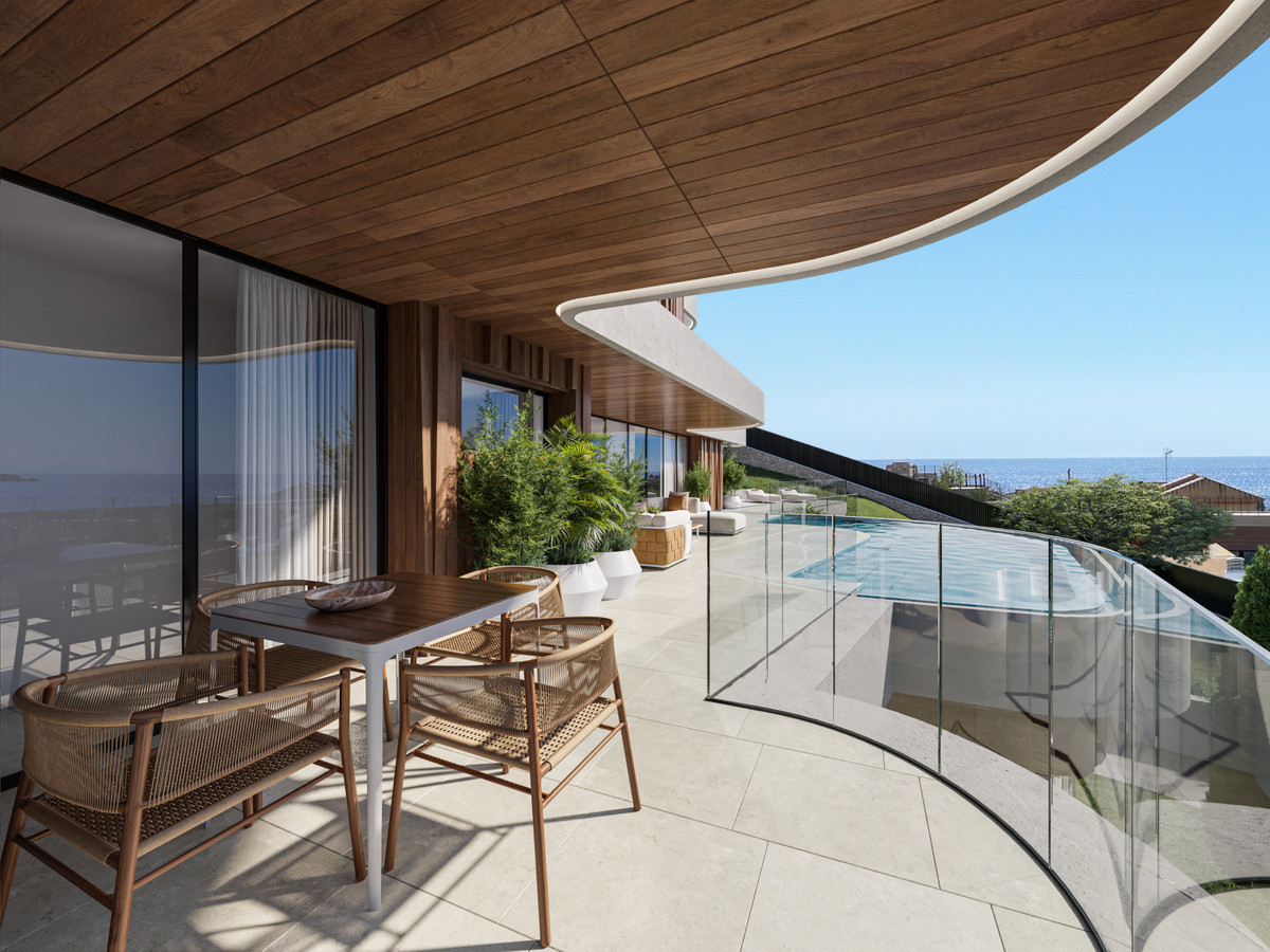 Modern balkon met uitzicht op de oceaan en luxe meubilair.