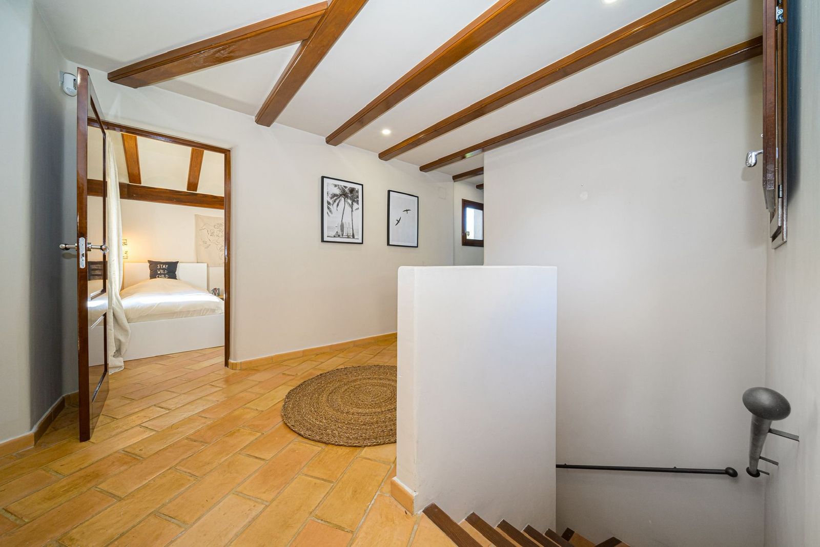 Hal met doorkijk naar slaapkamer en houten balken plafond
