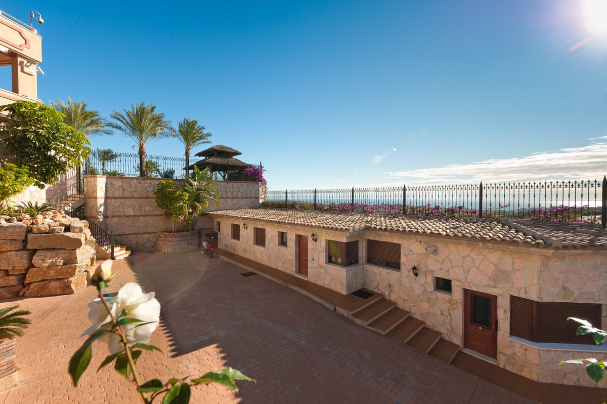 Buitenaanzicht van villa met binnenplaats en uitzicht op zee.