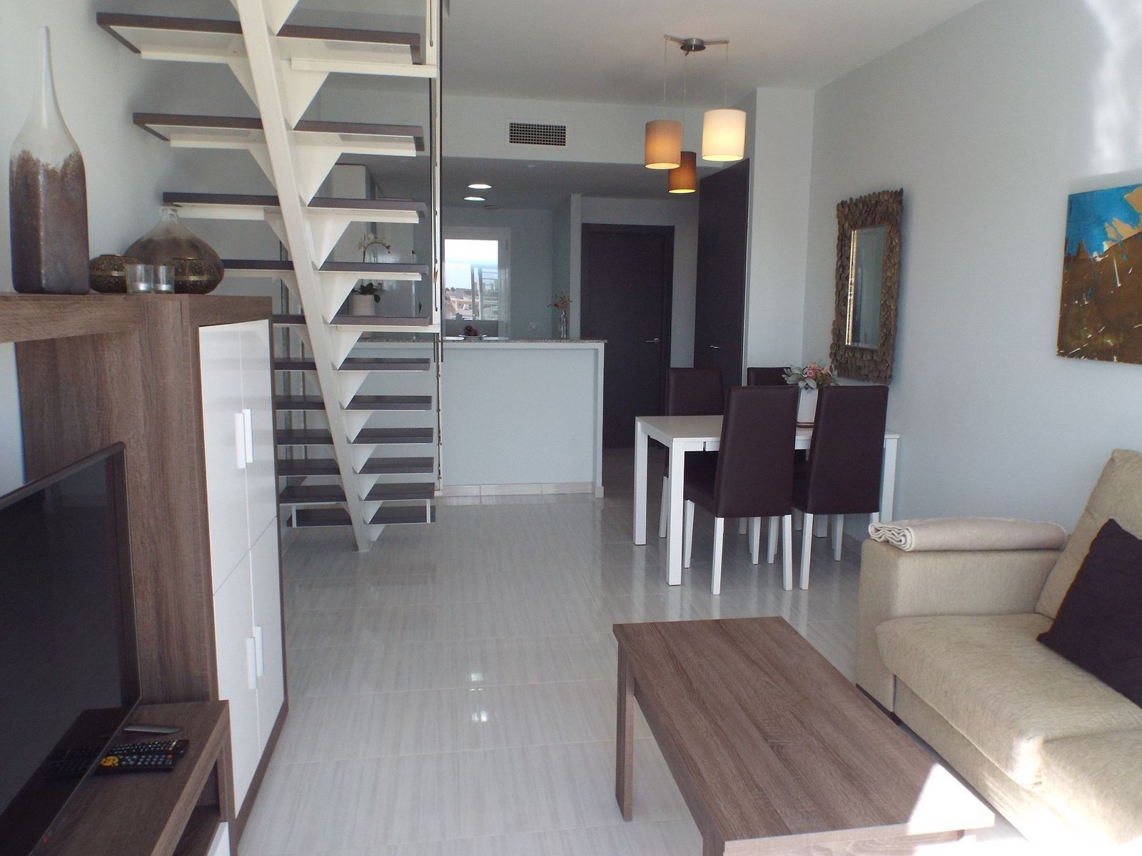 Moderne appartement woonkamer met eethoek en trap.