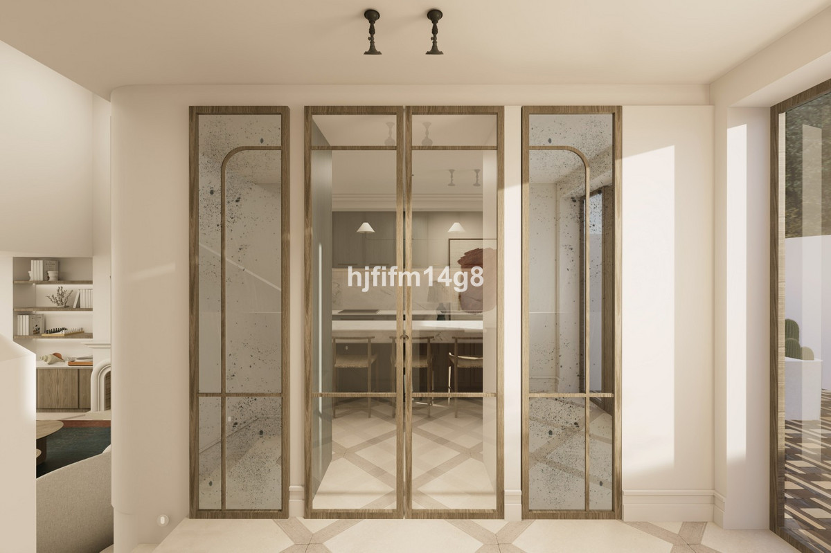 Hal met zicht op een strakke keuken door glazen deuren.