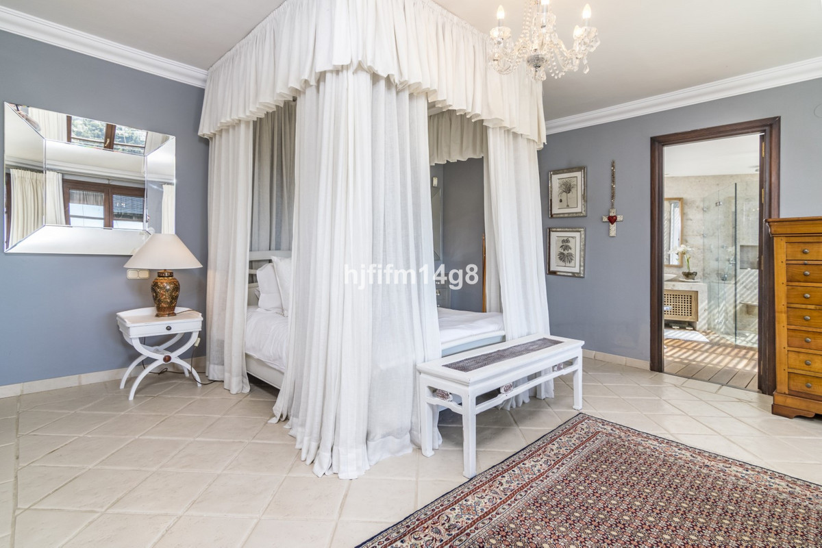 Slaapkamer met hemelbed en uitzicht op de badkamer.