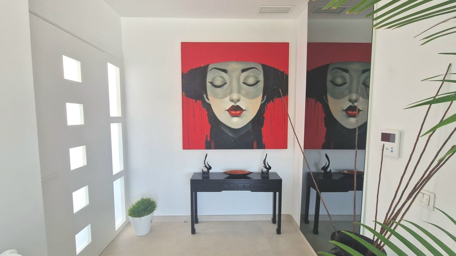 Stijlvolle entree met kunst en een modern interieur.