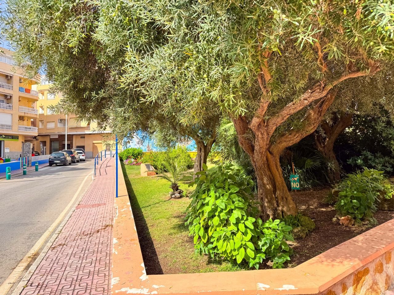 Alt text: Spacious living room with large windows offering a scenic view of the garden and pool.