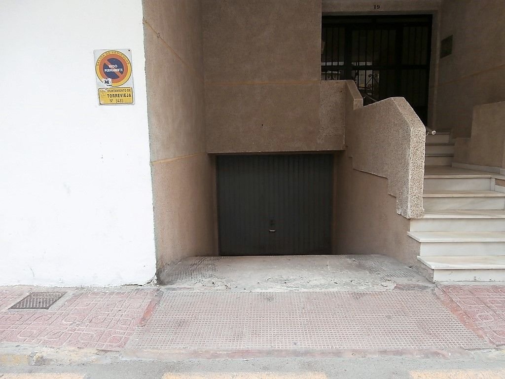 Small, carpeted room with a view of a staircase and a door.