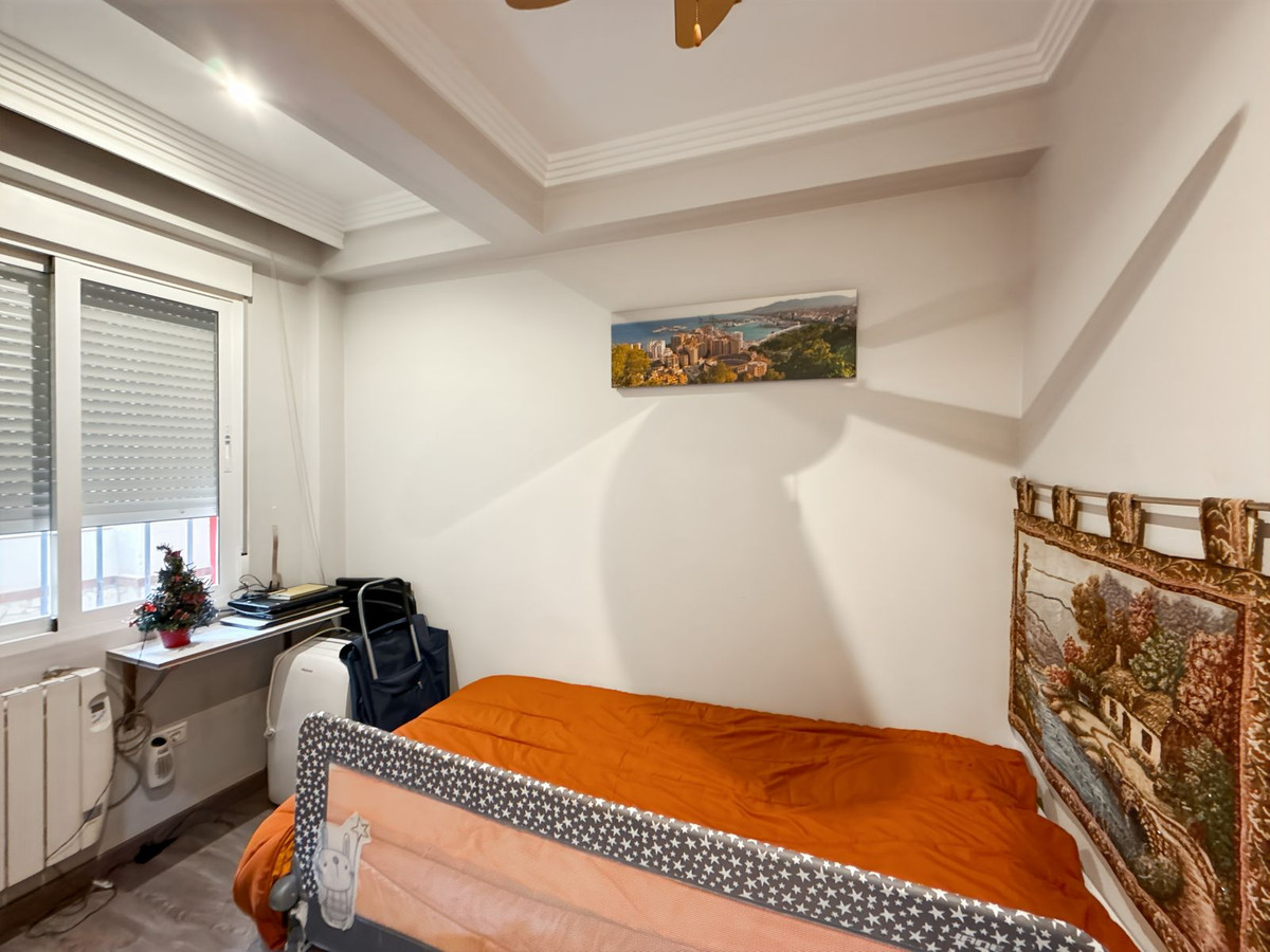 Gezellige slaapkamer met oranje beddengoed en decoratieve wandtapijten.