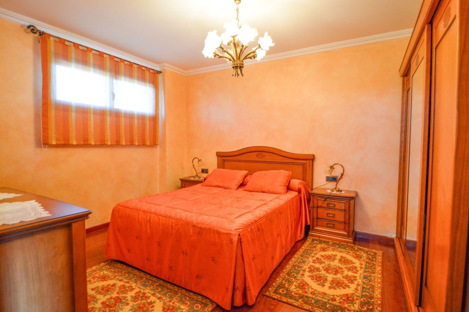 Oranje slaapkamer interieur met bed, nachtkastjes en een tapijt