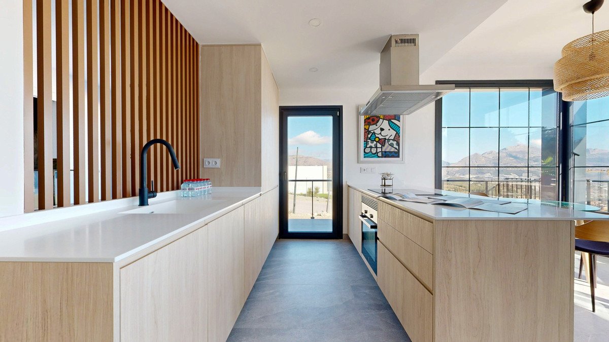 Modern kitchen with sleek cabinetry, a central island, and large windows offering a stunning mountain view.