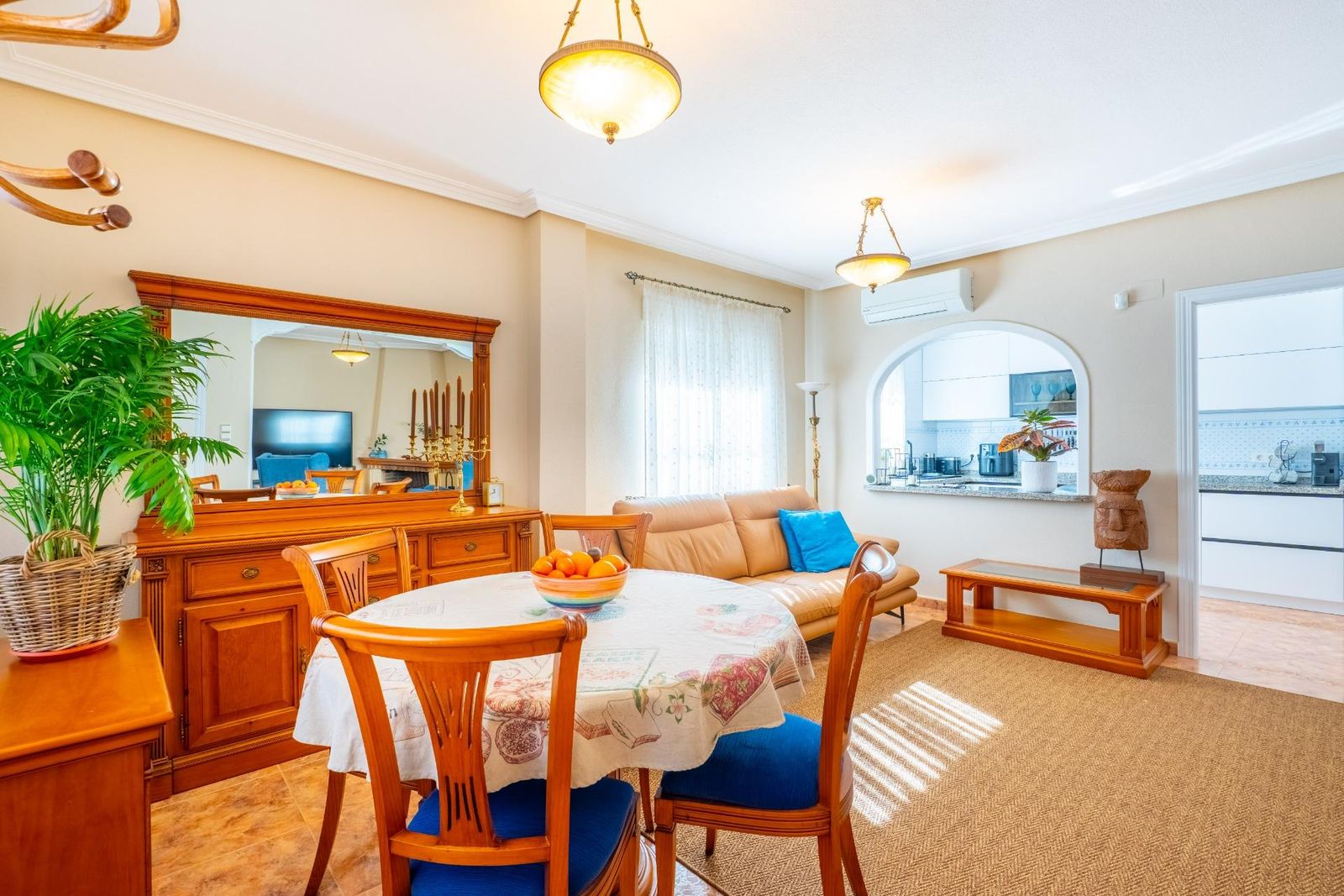 Interieur van een eet- en woongedeelte met houten meubels en blauwe accenten.