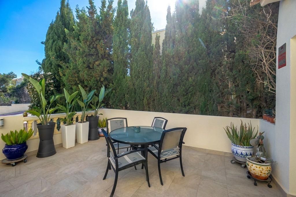 Buiten patio met tafel en stoelen, omgeven door groen