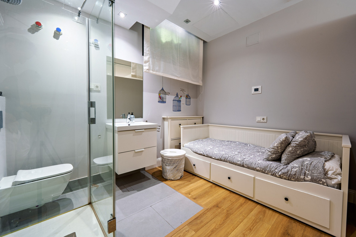 Interieur van slaapkamer met badkamer en wit bed en douchecabine